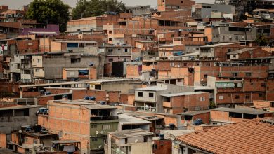 Vista aérea de telhados coloridos e moradias densamente agrupadas em uma comunidade de São Paulo