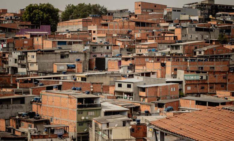 Vista aérea de telhados coloridos e moradias densamente agrupadas em uma comunidade de São Paulo